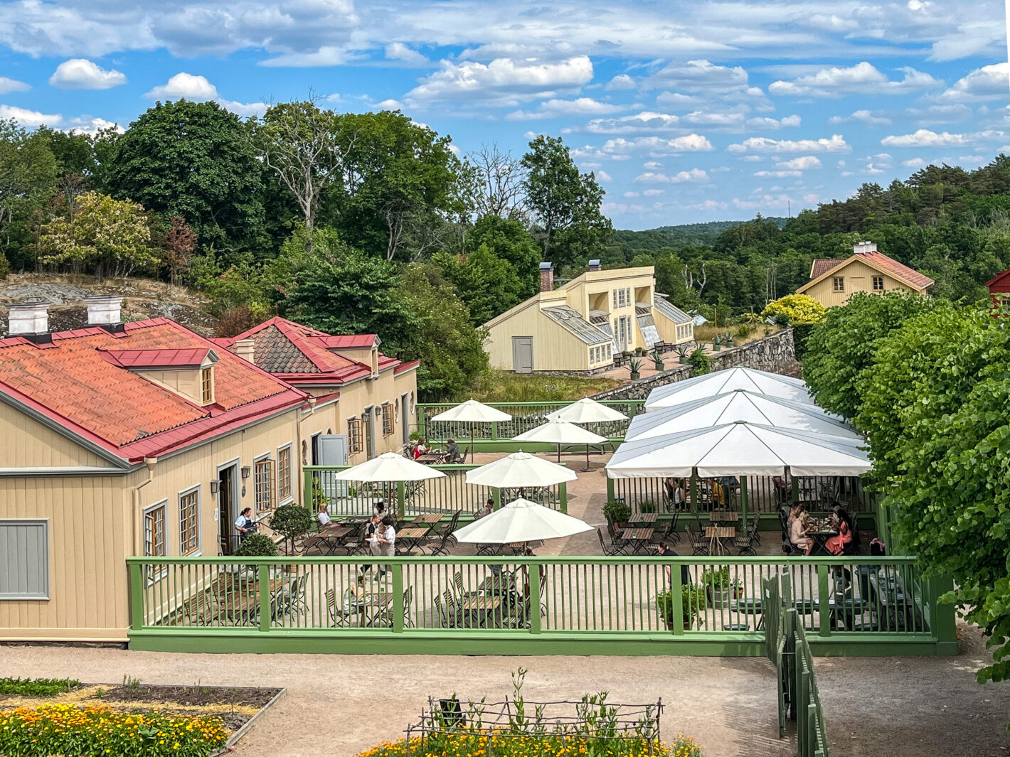 Uteservering på Gunnebo en solig dag bland grönskande natur