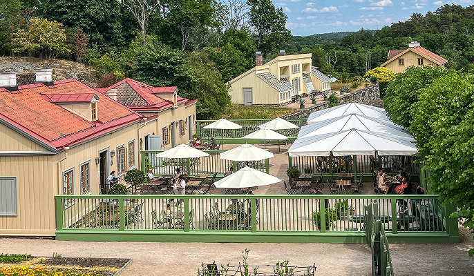 Fågelperspektiv över en myllrande uteserveringen till Gunnebos restaurang och café.
