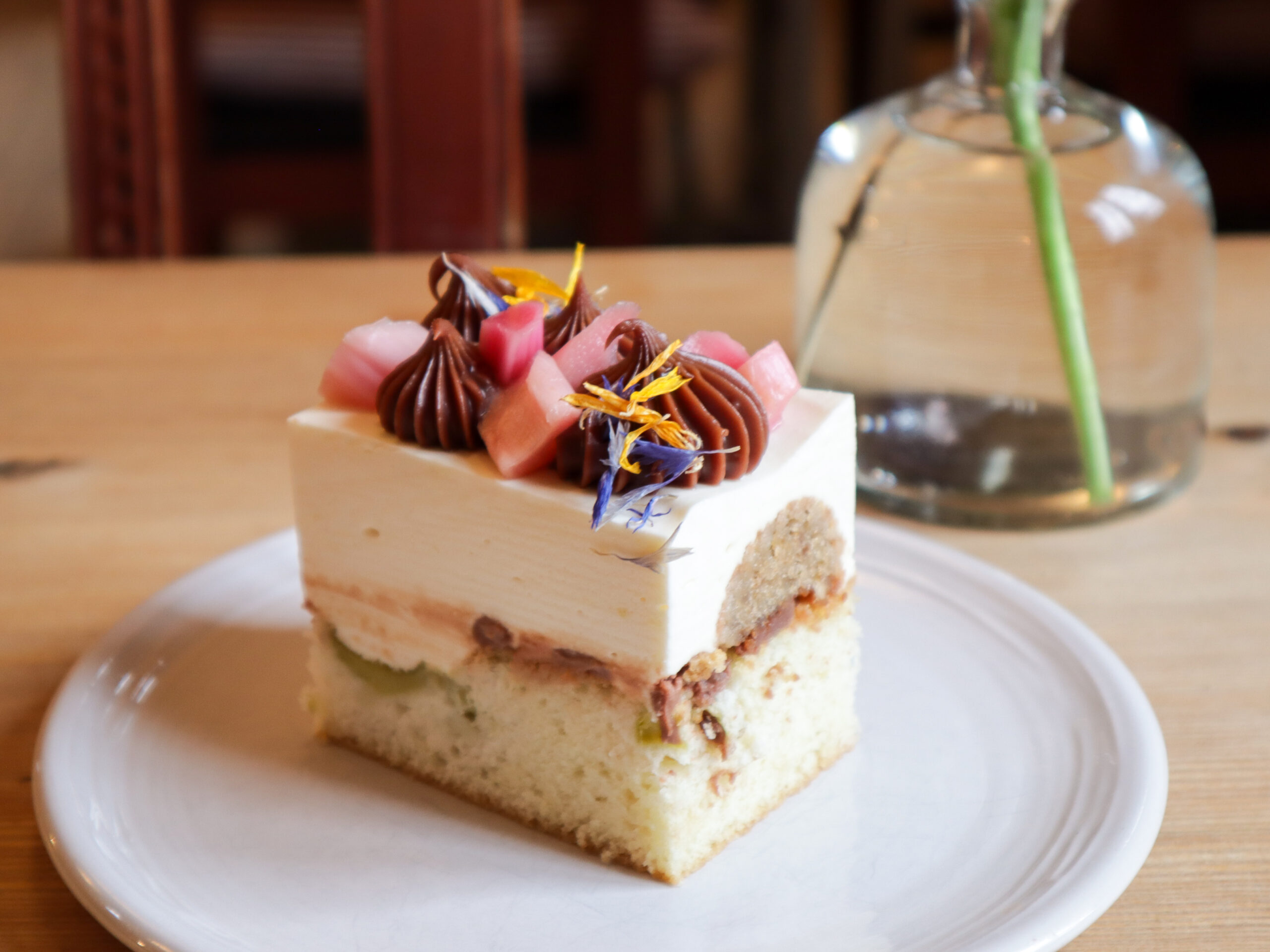 En vacker tårta i ljusa toner och garnityr på ett bord.